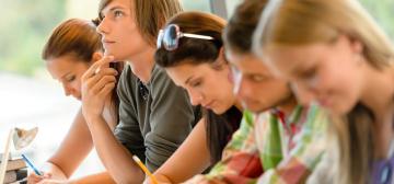 Students sitting in a row taking notes