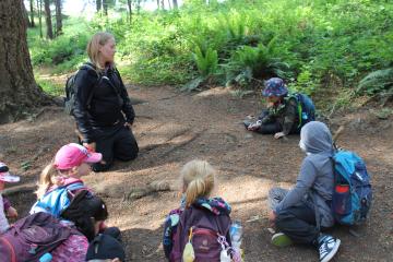 Children learning outside with teacher.